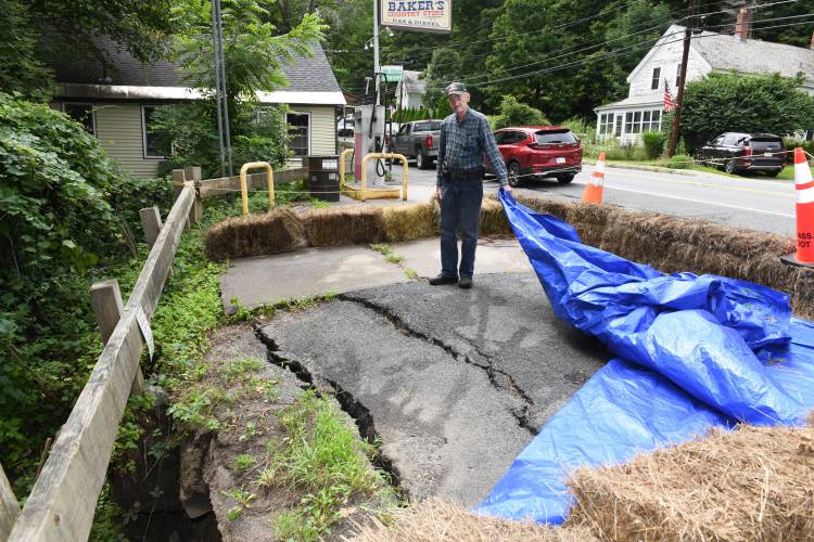 Robert Baker of Baker’s Country Store, pictured in August, reveals what heavy rains did to their parking lot. As the Bakers continue to try to address tens of thousands of dollars worth of damage that resulted from a July rainstorm, a chicken barbecue is set for Saturday, Oct. 19, to help raise more money.