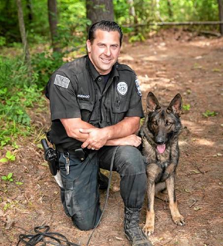 Montague Police Officer James Ruddock kneels next to his partner K-9 Artie. Ruddock and Artie spent close to a decade with each other until Artie was euthanized on Wednesday, Oct. 2.