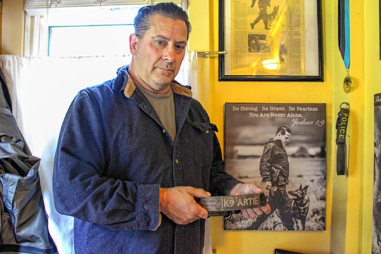 Montague Police Officer James Ruddock holds the collar of his late partner, K-9 Artie. Artie was euthanized on Wednesday, Oct. 2, after a sudden cancer diagnosis.