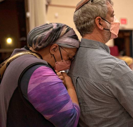 Amy Mager and her husband Dan Farfield listen as Sari Fein reads names of those who died in the Oct. 7, 2023 Hamas attack against Israel at a commemoration Monday at Congregation B’nai Israel in Northampton.