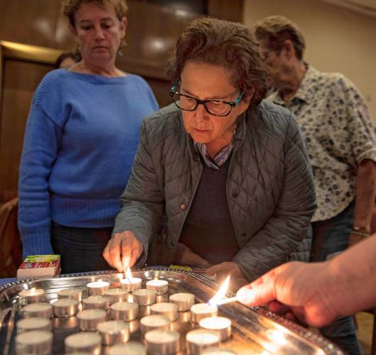 Amy Horowitz lights candles in honor of those who died in the Oct. 7, 2023 Hamas attack against Israel at a commemoration Monday at Congregation B’nai Israel in Northampton. 