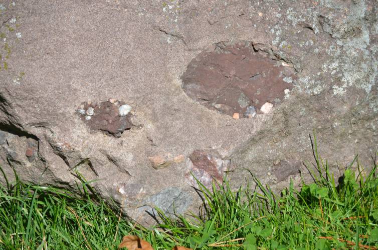 Jurassic armored mud balls consist of dark, lithified shale surrounded by pebbles. Richard Little, professor emeritus at Greenfield Community College, is seeking support in his ongoing effort to have Jurassic armored mud balls classified as the  state’s “official sedimentary structure.”