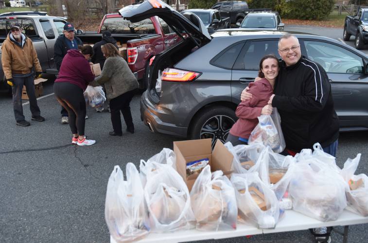 Turners Falls resident Ashley Patten gets a hug from organizer Robert “Bobby C” Campbell as she picks up a turkey and all the fixings for her family at the Bernardston Senior Center in 2022. For the ninth consecutive year, Campbell is soliciting donations to help feed local families on Thanksgiving. Donations must be received by Oct. 22.