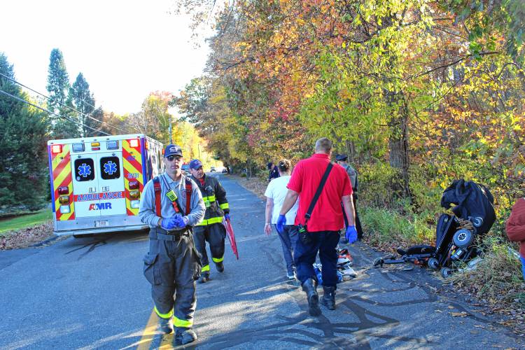 Greenfield Police officers and Franklin County Sheriff’s Office deputies move the wheelchair of one of the two women struck by a vehicle on Country Club Road in Greenfield on Friday afternoon.