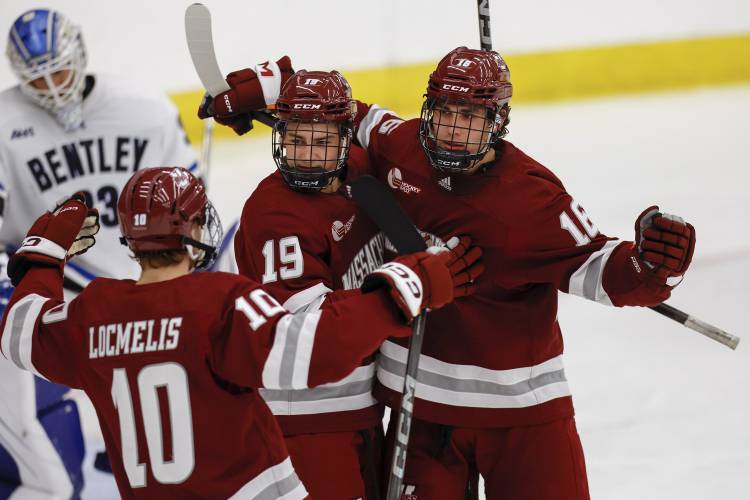 Massachusetts forward Aydar Suniev (16) celebrates with forward Cole O'Hara (19) and forward Dans Locmelis (10) after scoring a goal on Bentley goalie Connor Hasley (33) during action earlier this month in Waltham.