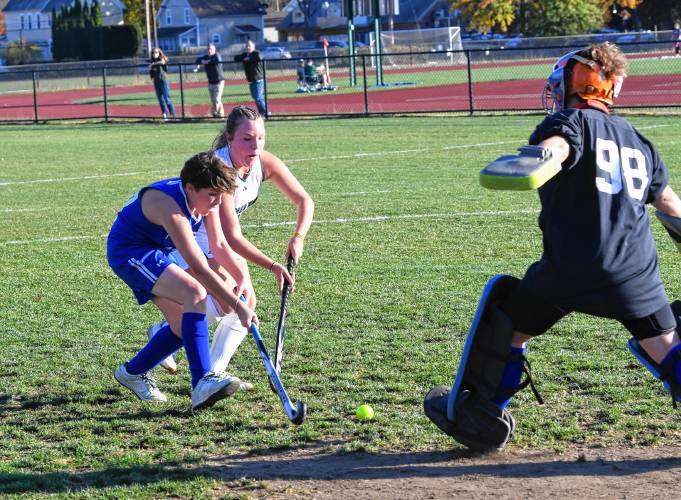 Turners Falls’ Patrick Andrews defends Greenfield’s Madison Lemay as Turners Falls’ Clara Guidaboni comes out of the goal to defend in Greenfield on Thursday. 