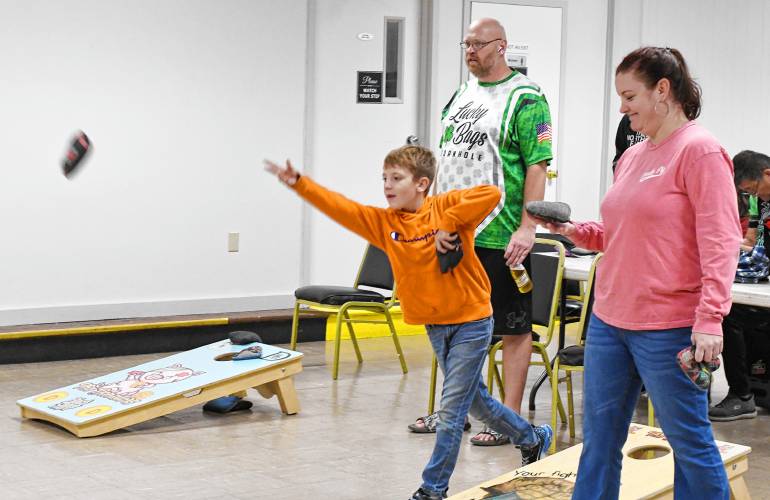 Ten-year-old Tyler Kuzmeskus plays next to his mother, Mary Sue Campbell, in the Franklin County Baggers cornhole league at the Montague Elks Lodge 2521 on Oct. 9.