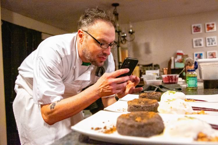 Chef Matthew Brehm takes photos of the dessert course, a “chocolate-canna lava cake,” inspired by a Joël Robuchon recipe, with wild berry sauce, candied walnuts, a “canna-cookie,” vanilla gelato, and mint dust, for his business Instagram.