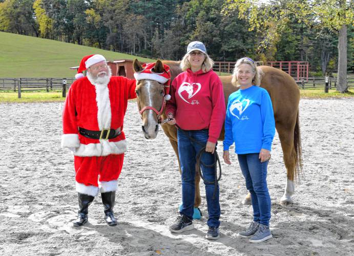 Santa, also know as Jeffrey Gordon, with Logan the horse, and Deb Gordon and Lindsay McCarthy of the Courageous Strides therapeutic riding program in Bernardston. 