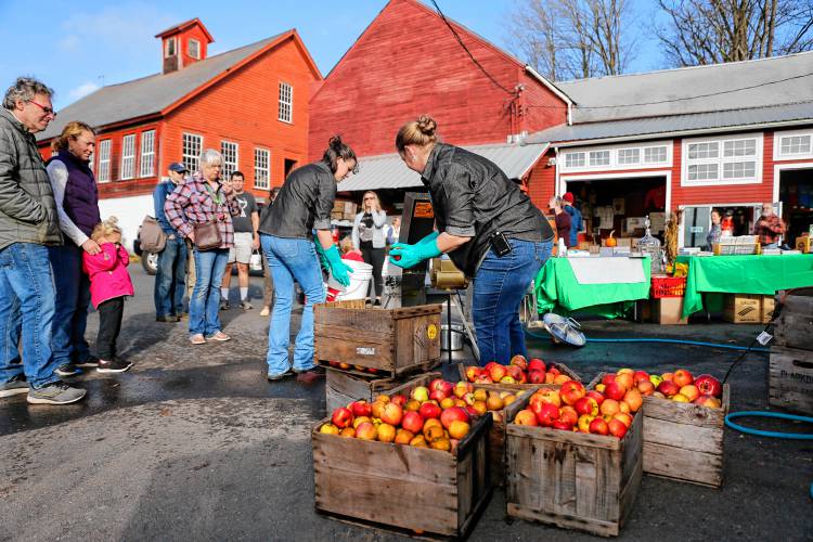 Gemma Vanderheld, right, and Rebecca Ryan demonstrate cider pressing equipment from Conway’s OESCO, Inc. at Clarkdale Fruit Farms in Deerfield during Cider Days weekend festivities in 2022.