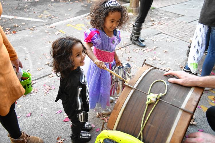 Zsa’Vaeya McGahan, 3, and sister Mirasia McGahan beat Dave Noonan’s drum while trick-or-treating in Greenfield.