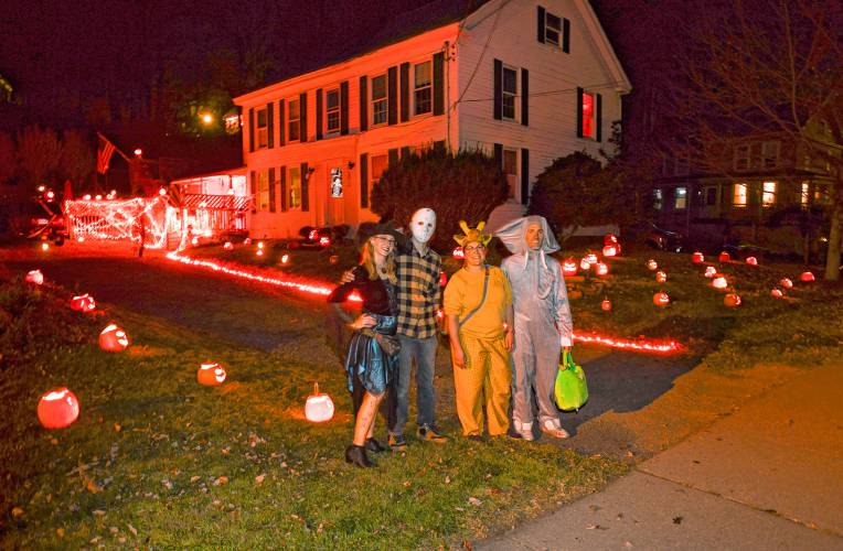 Characters pose for a picture at a house on River Street (Rt. 116) in Conway that was adorned with dozens of carved and lit pumpkins on Halloween night.