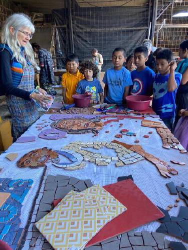 Cindy Fisher shows kids in Guatemala how she makes mosaics.