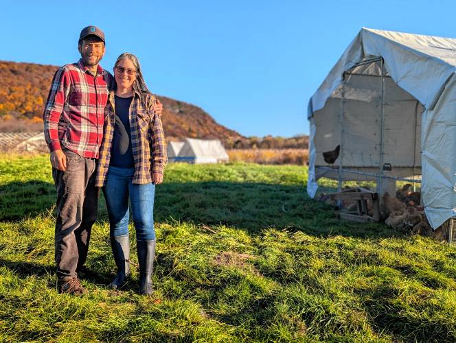 Robert Friedman and Shemariah Blum-Evitts in pasture with their chicken coops at Robariah Farms in South Deerfield.