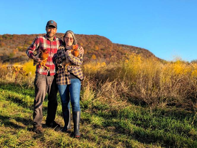 Robert Friedman and Shemariah Blum-Evitts holding two of their laying hens at Robariah Farms in South Deerfield.