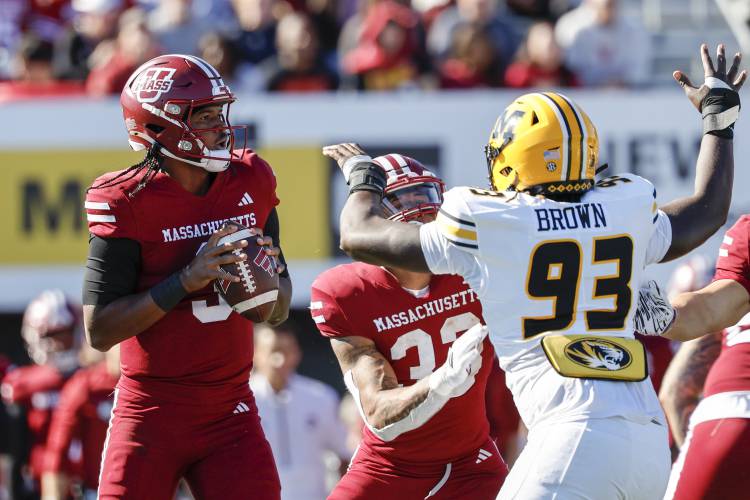 UMass quarterback Taisun Phommachanh (3) prepares to make a pass while running back CJ Hester (33) keeps Missouri defensive end Jaylen Brown (93) away during action earlier this season in Amherst.