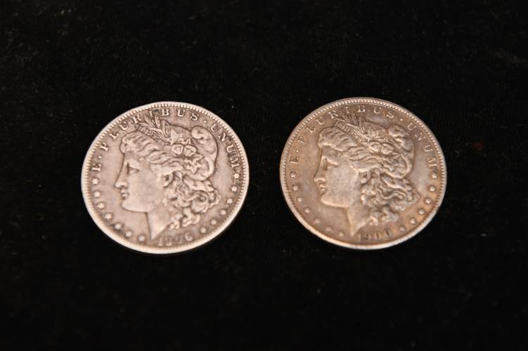 A real and a fake Morgan silver dollar at Gary’s Coins and Antiques in Turners Falls. The fake, on the right, weighs less than the real one and makes a different sound when dropped on a hard surface, just two signs of a fake.