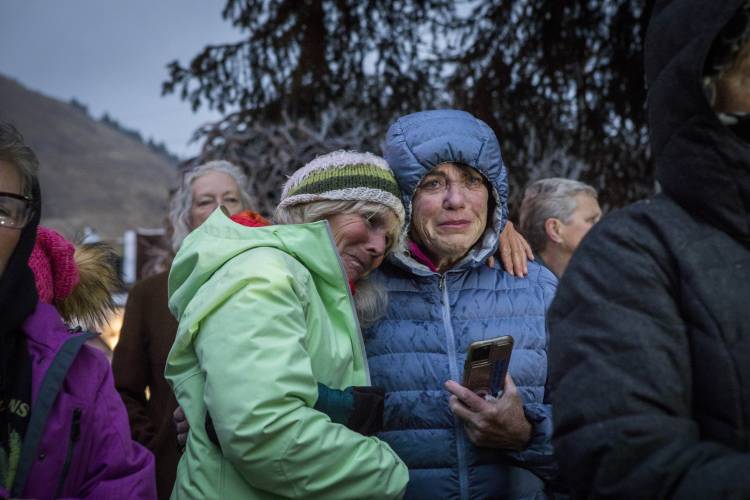 Trina Gioshes comforts Mari Auman as they mourn the loss of grizzly bear No. 399 during a candlelight vigil in Jackson, Wyo., Saturday, Nov. 2, 2024.