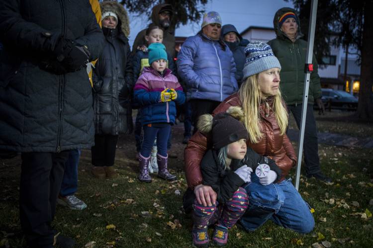 Rae Smith, 6, and her mother Leigh Reagan Smith listen to speakers at a candlelight vigil for grizzly bear No. 399 in Jackson, Wyo., Saturday, Nov. 2, 2024.