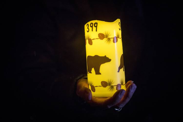 Catherina Gallegos holds a decorated candle in memory of grizzly bear No. 399 at a candlelight vigil in Jackson, Wyo. on Nov. 2, 2024.