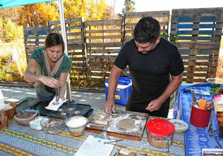 Anna Barto and Benjamin Lester of the Pioneer Valley Heritage Grain Share make small pitas out of ancient einkorn topped with red merlot bean hummus and tzatziki at Just Roots in Greenfield.