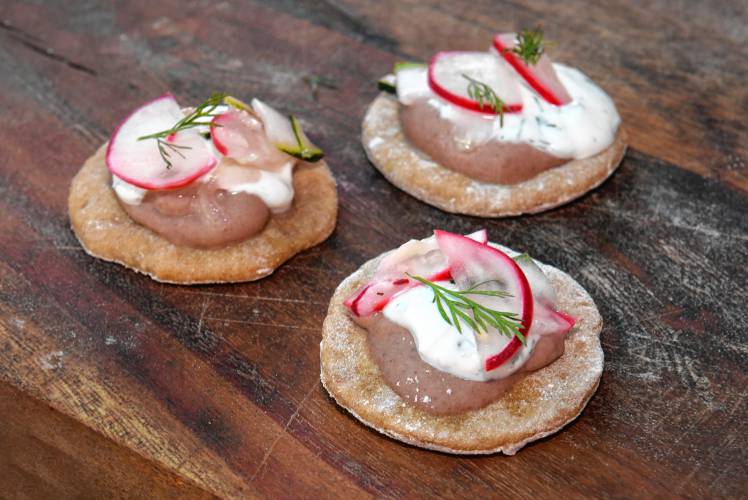 Pitas made with ancient einkorn topped with red merlot bean hummus and tzatziki.