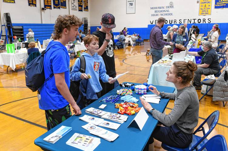 Students Ricky Gianfrancesco, Liam Zarotny and Brody Cole talk with Julia Popkin of Community Legal Aid at the West County Community Resource Fair at the Mohawk Trail Regional School.