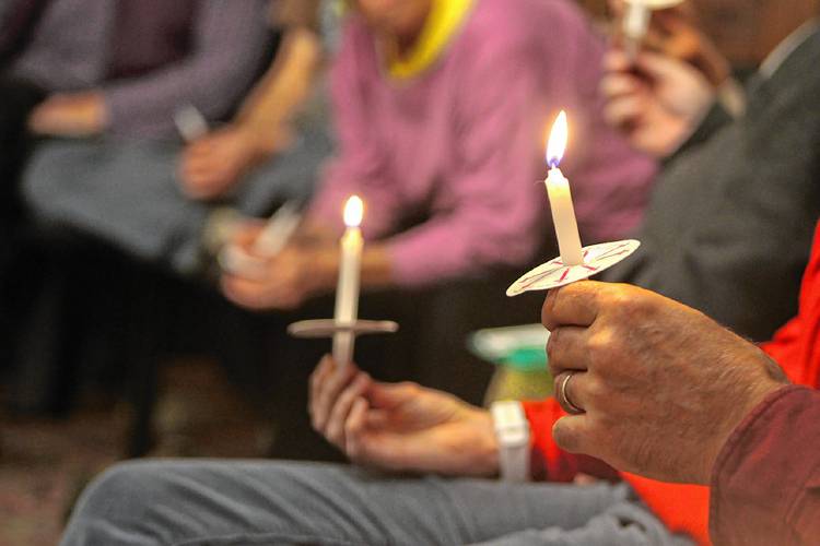 Attendees hold candles during a pre-election prayer gathering organized by the Interfaith Council of Franklin County at the Episcopal Church of Saints James and Andrew in Greenfield on Monday.