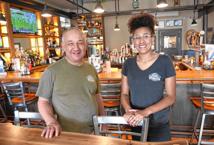 Main Street Bar & Grille co-owner Tom Gurney and bartender/server Kiana McGraw, pictured in the Greenfield eatery on Thursday. Co-owner Christina Guezin-Gurney said passage of Question 5 during Tuesday’s election would have indirectly resulted in higher meal prices for customers, and consequently, smaller tips for servers. The measure was voted down.