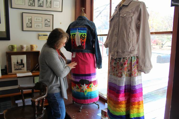 Curator Sky Suslov shows off ribbon skirts on display at the Ashfield Historical Society Museum