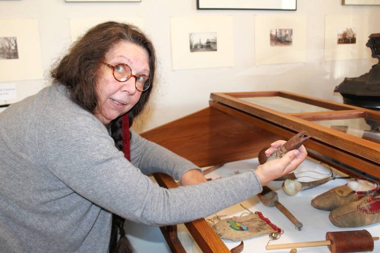 Curator Sky Suslov shows off various Indigenous tools made by her relatives.