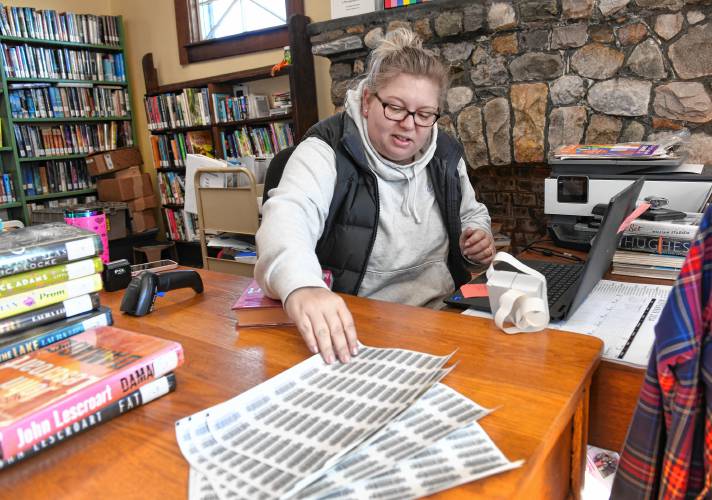 Karin Parks, library director at Robertson Memorial Library in Leyden, assigns barcodes to books in the collection so the library can participate in the Central and Western Massachusetts Automatic Resource Sharing (CWMARS) system.