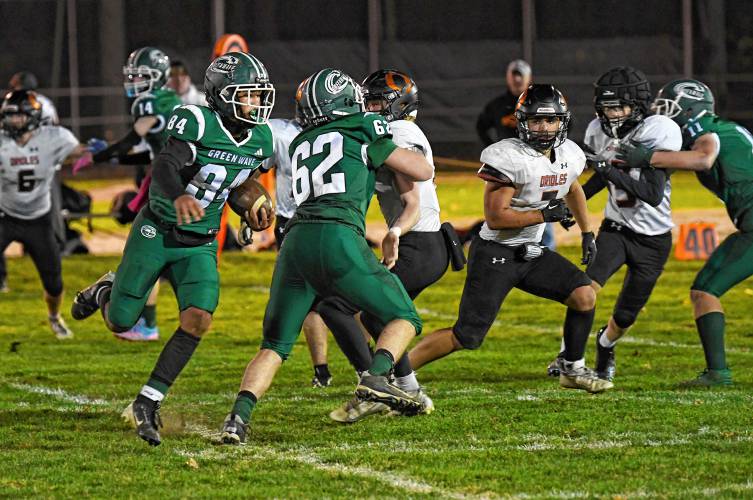 Greenfield’s Angel Politis takes advantage of a block by Jackson Killeen (62) for extra yardage against Belchertown during the Green Wave’s 46-13 win at Veterans Memorial Field in Greenfield Friday night. 