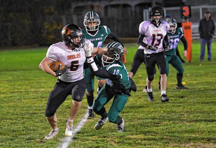 Greenfield’s Caleb Murray tackles Belchertown’s Brian Fuller during the Green Wave’s 46-13 win at Veterans Memorial Field in Greenfield Friday night. 