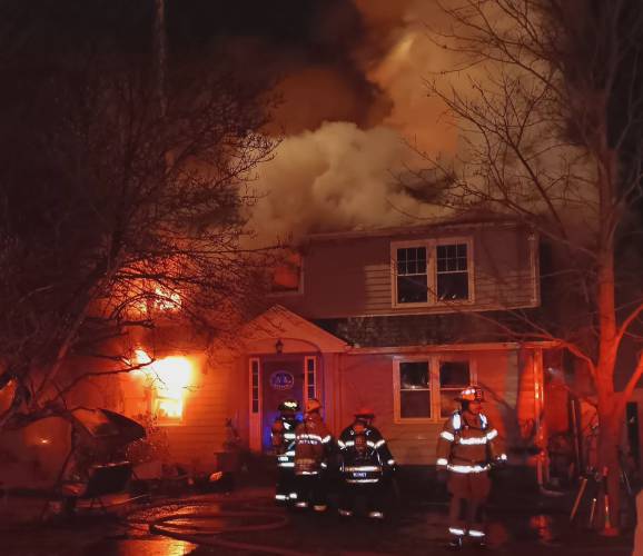 Firefighters work to extinguish a house fire at 99 West River St. in Orange on Dec. 13, 2023.