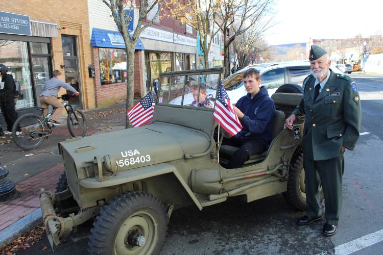 Veteran Norman Cousino watches as Matthew and Mason Andrews examine his 1944 Army-issue Jeep in Greenfield on Monday.