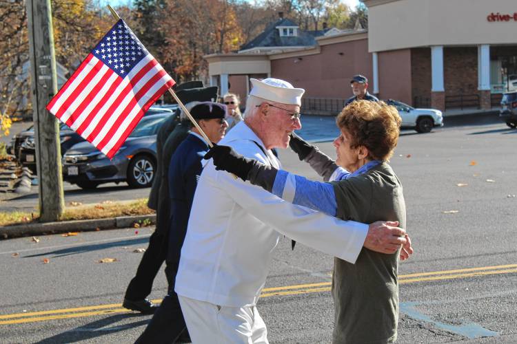 Navy veteran George Platek hugs a spectator while marching in the Greenfield Veterans Day parade on Monday.