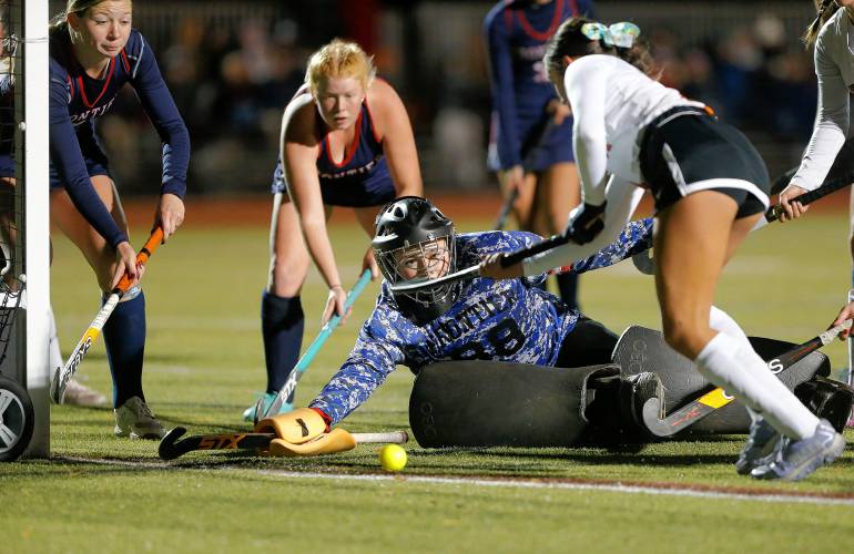 Frontier goalkeeper Kyra Richards dives to block a shot against Uxbridge’s Addie Blood (4) in the first half of the MIAA Div. 4 field hockey state semifinal Tuesday at Agawam High School.