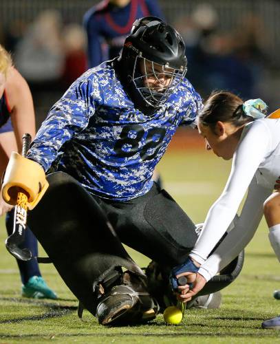 Frontier goalkeeper Kyra Richards blocks a shot against Uxbridge’s Addie Blood (4) in the first half of the MIAA Div. 4 field hockey state semifinal Tuesday at Agawam High School.