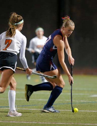 Frontier’s Elsa Brown (7) carries the ball defended by Uxbridge’s Aubrey Bouchard (7) in the first half of the MIAA Div. 4 field hockey state semifinal Tuesday at Agawam High School.