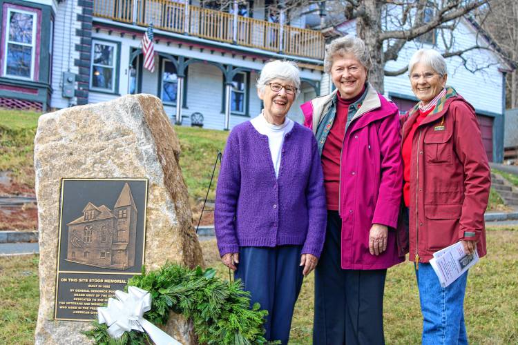 From left, Janice Lanou, Pamela Rand and Pamela Oddy stand together at the new stone and bronze plaque dedicated to the former Memorial Hall at the corner of Prospect and High streets behind Orange Town Hall. Memorial Hall was demolished in 1996.