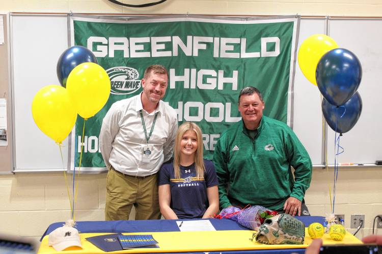 Greenfield’s MacKenzie Paulin with Greenfield principal Michael Browning (left) and Greenfield athletic director Mike Kuchieski (right) after signing her National Letter of Intent on Wednesday to play softball at Merrimack College next fall. 