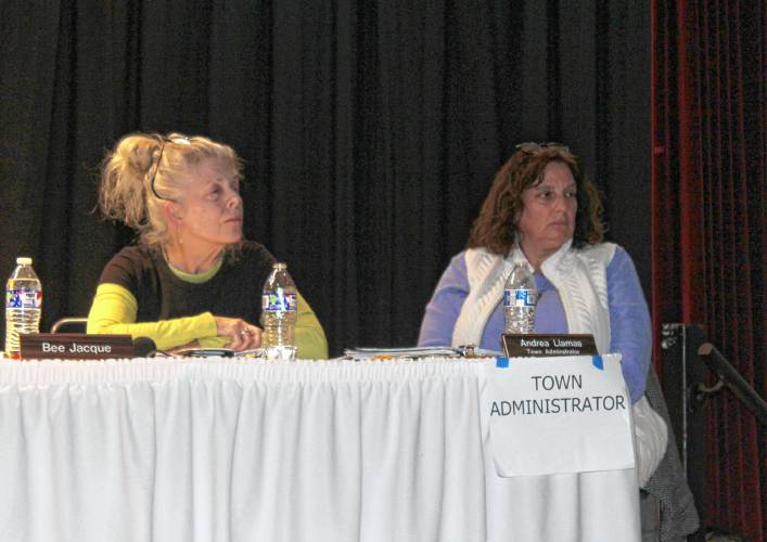 Northfield Selectboard member Barbara “Bee” Jacque, left, and Town Administrator Andrea Llamas sit on the stage of Pioneer Valley Regional School’s auditorium during Wednesday’s Special Town Meeting. The warrant included an unsuccessful citizen’s petition article to abolish the town administrator position.