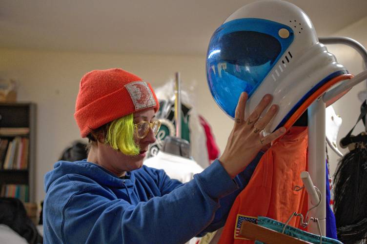 Swanson’s Fabrics owner Kathryn Greenwood Swanson with a helmet from one of Christopher “Monte” Belmonte’s outfits used during the annual march to support the Food Bank of Western Massachusetts.