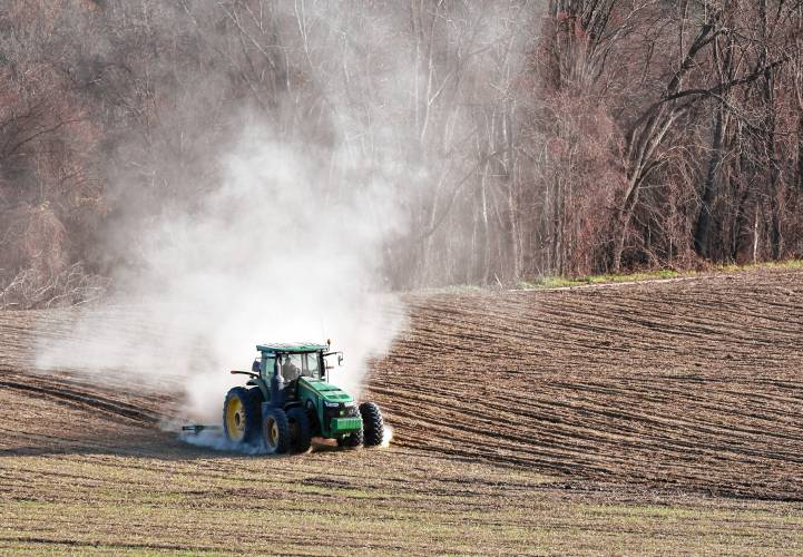 A tractor kicks up a cloud of dust as a farmer turns over this dry field in Gill. 