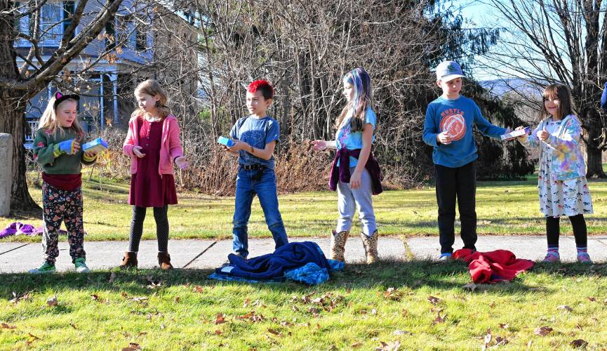 Northfield Elementary School students pass nonperishable items down the line as the school’s annual food drive concludes on Wednesday by transferring the collected items to the Northfield Food Pantry, located in the basement of Dickinson Memorial Library. 