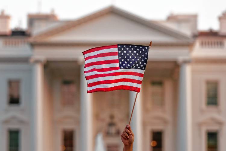 A flag is waved outside the White House, in Washington, D.C.