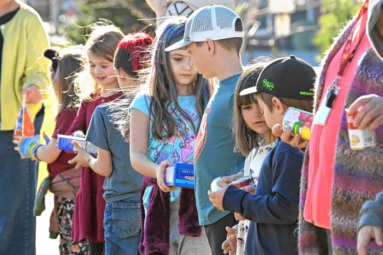 Northfield Elementary School students pass nonperishable items down the line as the school’s annual food drive concludes on Wednesday by transferring the collected items to the Northfield Food Pantry, located in the basement of Dickinson Memorial Library. 