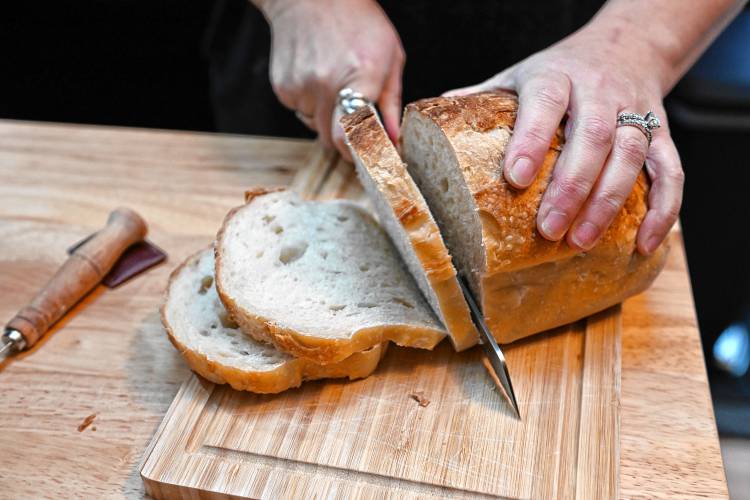 Slicing a loaf of sourdough bread at The Sourdog, a cottage bakery, in Orange.