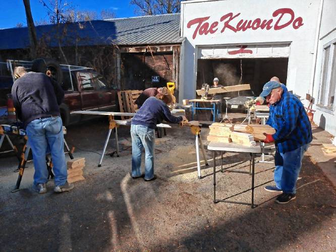 Greenfield Tae Kwon Do Center instructors and members help cut planks into smaller boards for the center’s annual “Break-athon” fundraiser for Warm the Children.